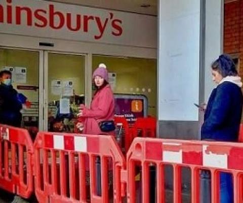 Social distancing while lining up at a supermarket. Credit: Philafrenzy/Wikimedia Commons