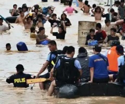 People wade in the chest deep floodwater in suburban Cainta, east of Manila, Philippines, in 2009. Such events will affect twice as many people by the end of the decade. Photograph: Pat Roque/AP