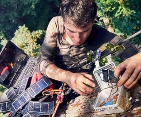 Topher White of Rainforest Connection installing a bioacoustic device in the forest canopy. Image by Ben Von Wong.